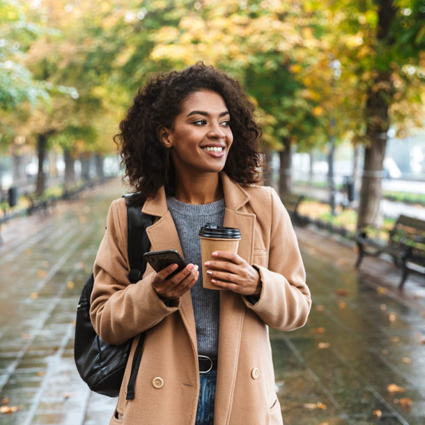 Beautiful young african woman wearing coat walking outdoors