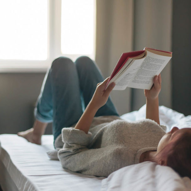 Girl reading a book in bedroom