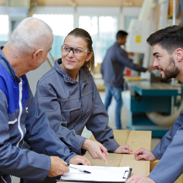 factory workers with clipboard working together