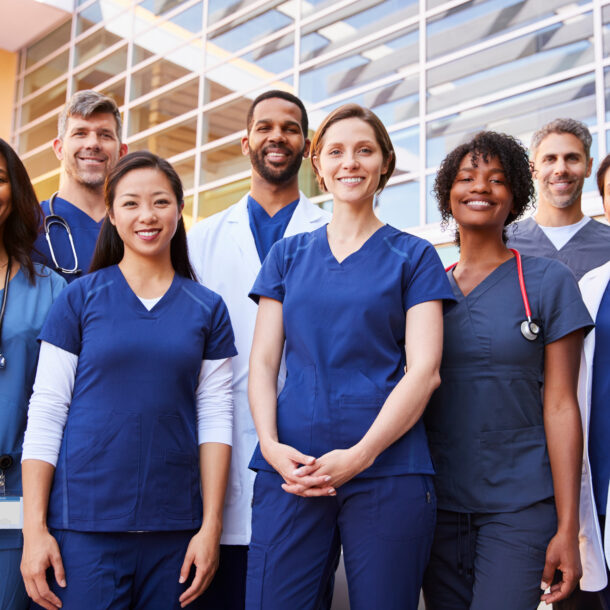 A team of healthcare professionals standing outside a hospital.