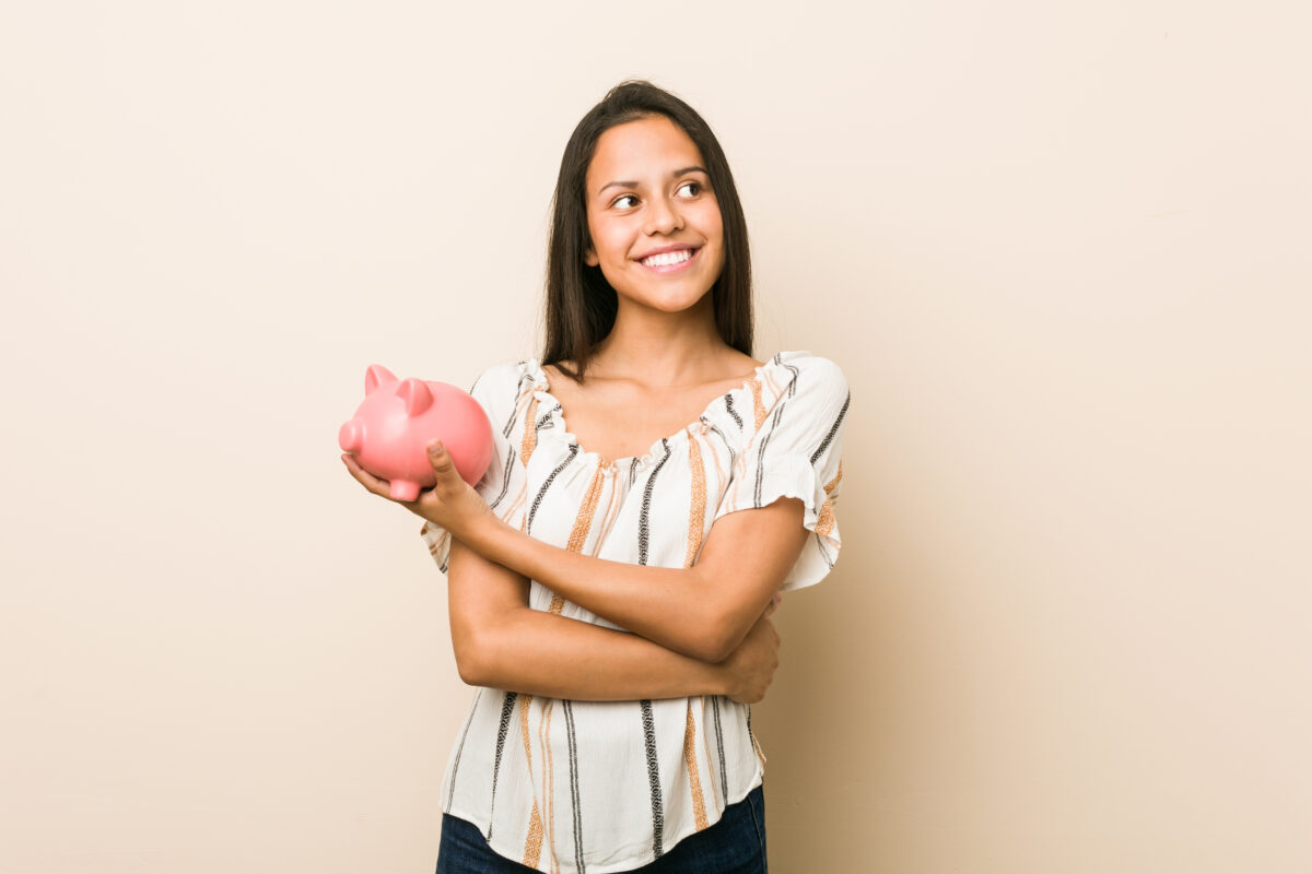 A woman holding a piggy bank