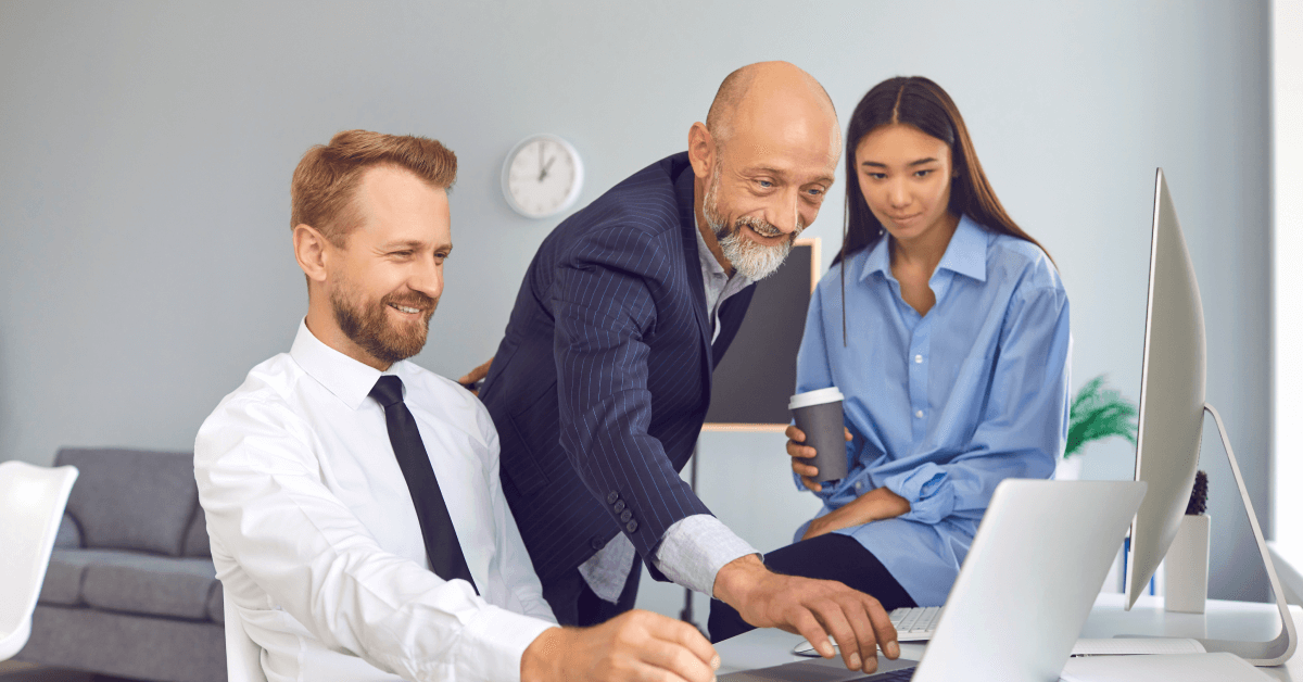 Happy office workers using laptop to work on project or to watch funny video during break