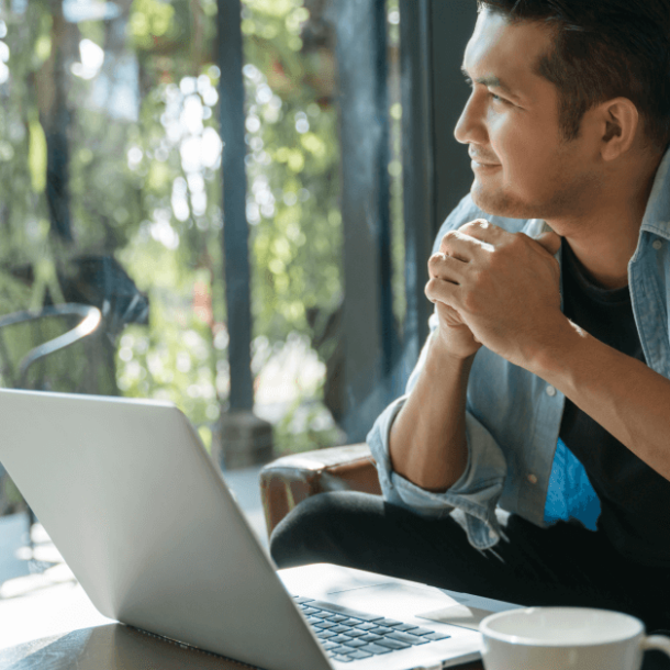 man sitting happily looking out of the window in a cafe.