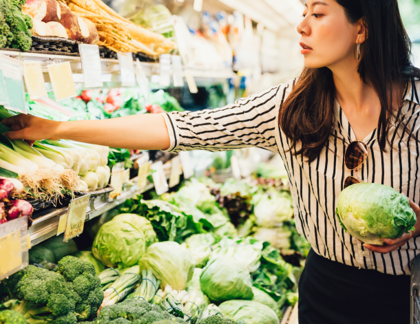 Woman with food basket at grocery or supermarket