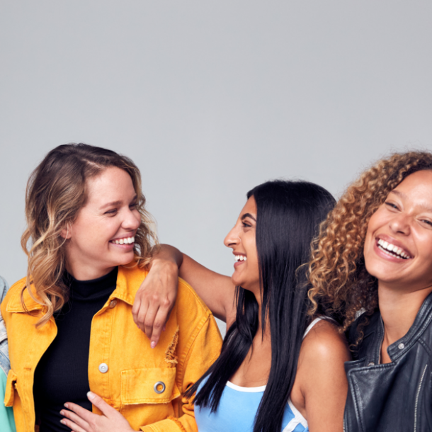 Group Studio Portrait Of Multi-Cultural Female Friends Smiling Into Camera Together
