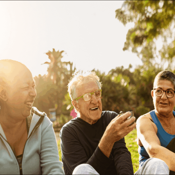 Happy multiracial senior friends drinking a tea after workout activities in a park