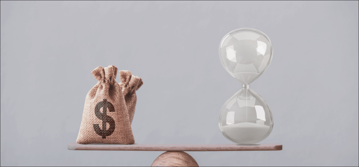 Financial concept : Write sand clock or hourglass symbol and dollar bagson a balance scale in equal position.Time value of money, asset growth over time, investment in long-term equity for more money